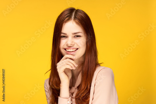 happy red-haired woman on yellow background, pink shirt