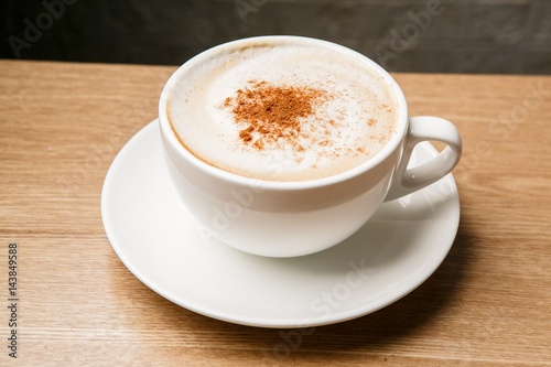A cup of cappuccino on wooden table