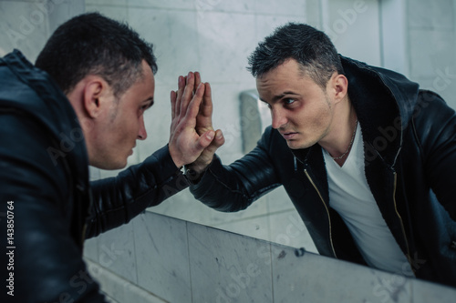 Quite wealthy man in a public toilet with the beaten person looks in a mirror. He looks to himself in the face, as in soul.