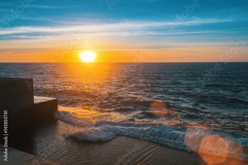 Wonderful sunset at the sea pier, flare and rays. photo