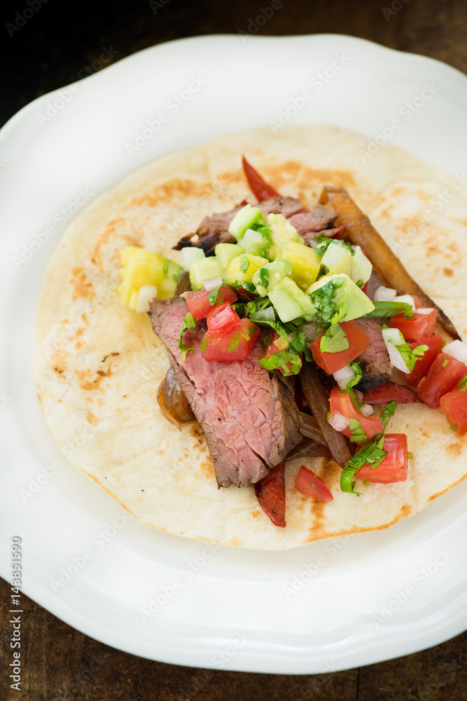 Beef fajitas served over tortilla