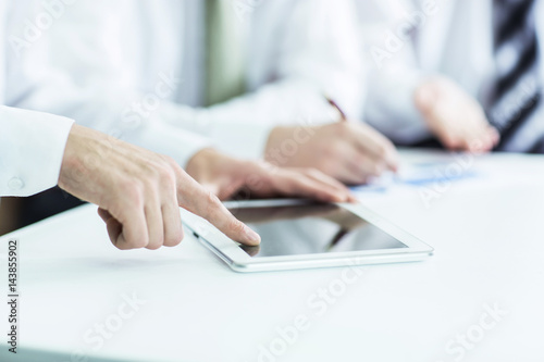 business team using digital tablet, working with the financial schedule of the company's development