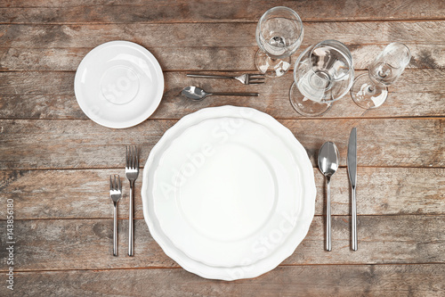 Beautiful table setting with white plates on wooden table