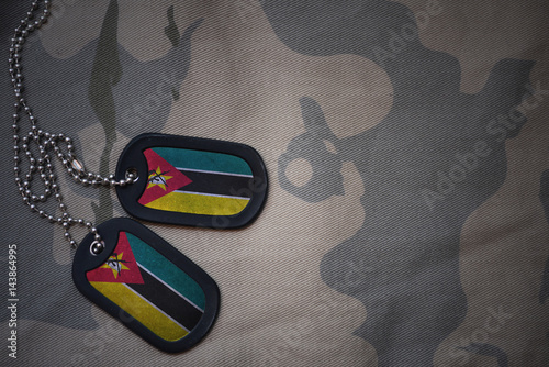 army blank, dog tag with flag of mozambique on the khaki texture background. military concept