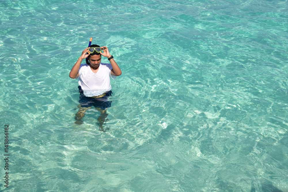 man is snorkeling in crystal clear sea water