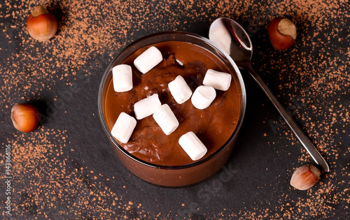 Chocolate mousse with marshmallows in portion glasses on slate cheese board