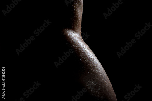 Beautiful sexy naked female body, in oil with drops of water on the body, tender bends of the naked waist and hips gorgeous in the darkness.