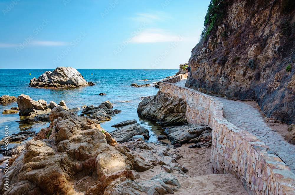 panoramic view of seashore with rock cliff and a road