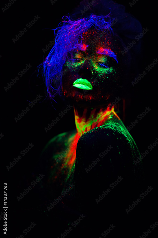 Beautiful extraterrestrial model woman with blue hair and green lips in neon  light. It is portrait