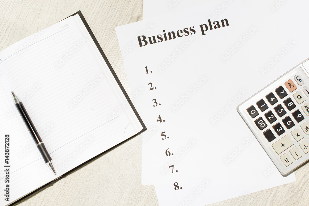 An inscription of the business plan, execution points, there is a notebook and a calculator next to it An inscription of the business plan, execution points, there is a notebook and a calculator next to it