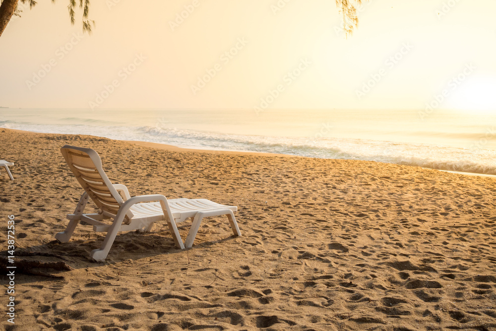 Naklejka premium white chair on sand beach in morning light