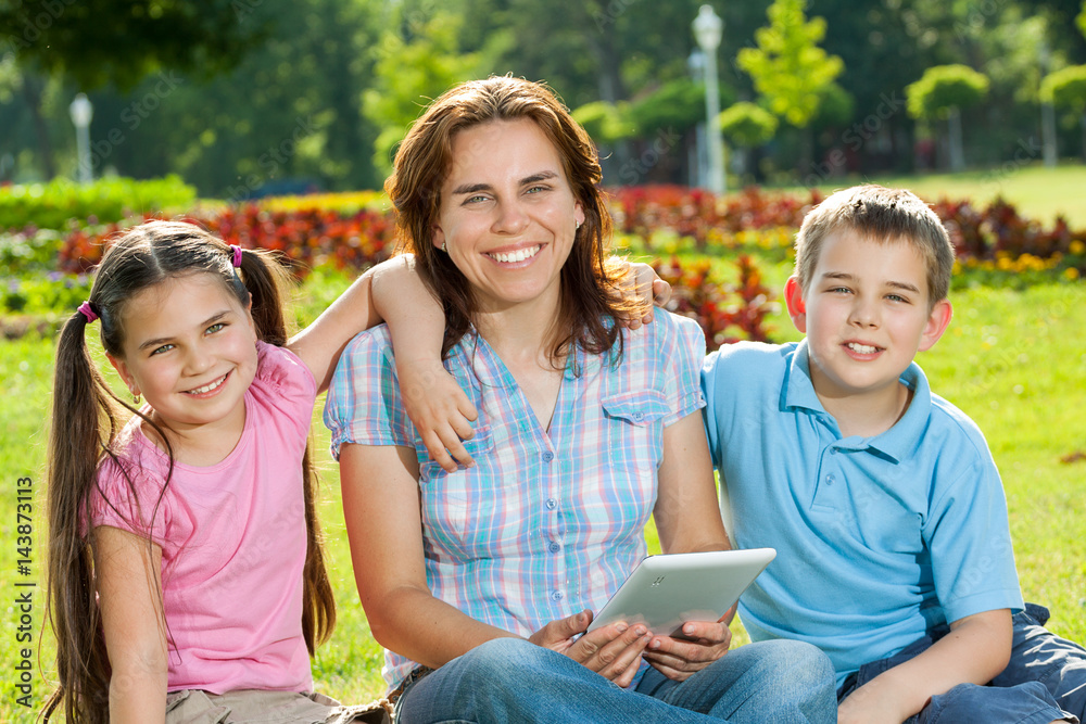 Happy Family using laptop lying on grass Happy Family using laptop lying on grass