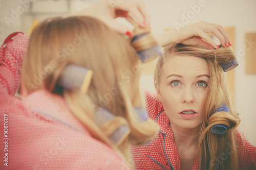 Woman curling her hair using rollers