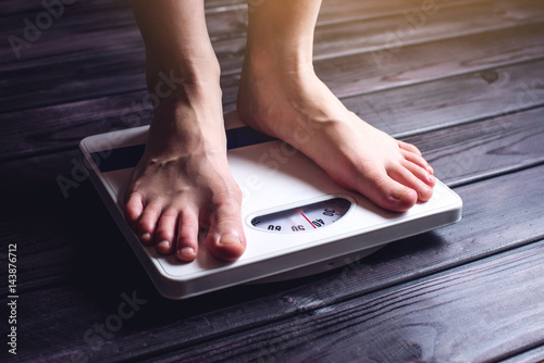 Women's feet are on mechanical scales for weight control