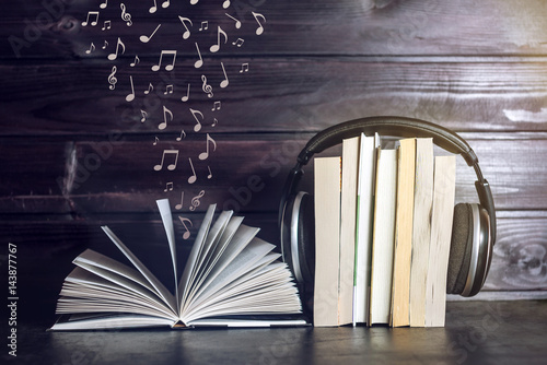 Foto Headphones on books and flying notes. The concept of audiobooks