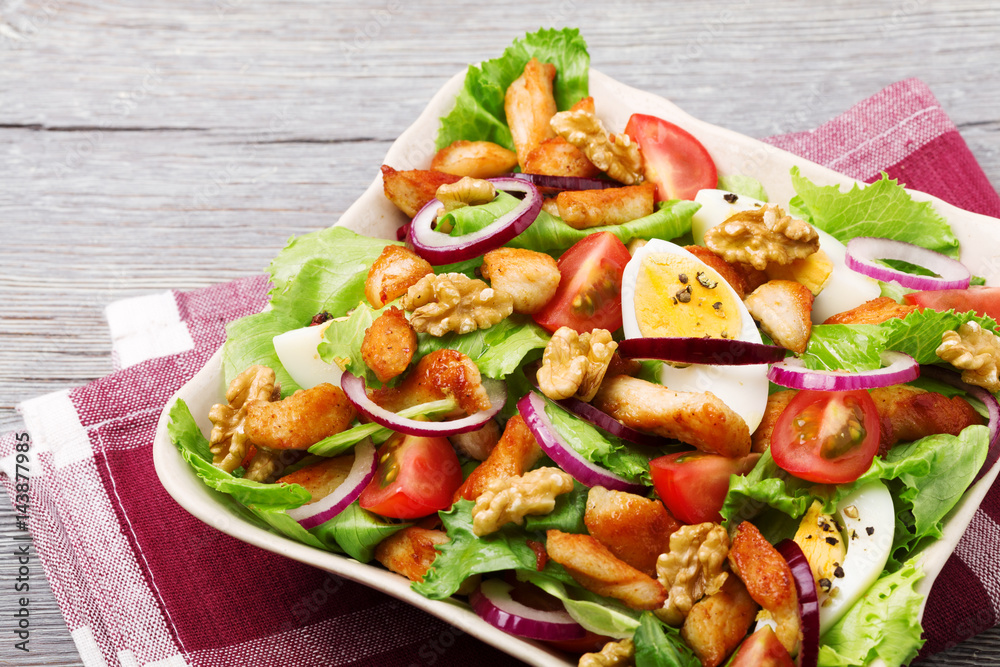 Delicious salad with chicken, nuts, egg and vegetables. Delicious salad with chicken, nuts, egg and vegetables.