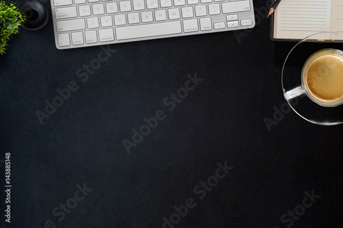 Modern dark surface office desk table with computer and cup of coffee. Hero Header Concept with Copy space.