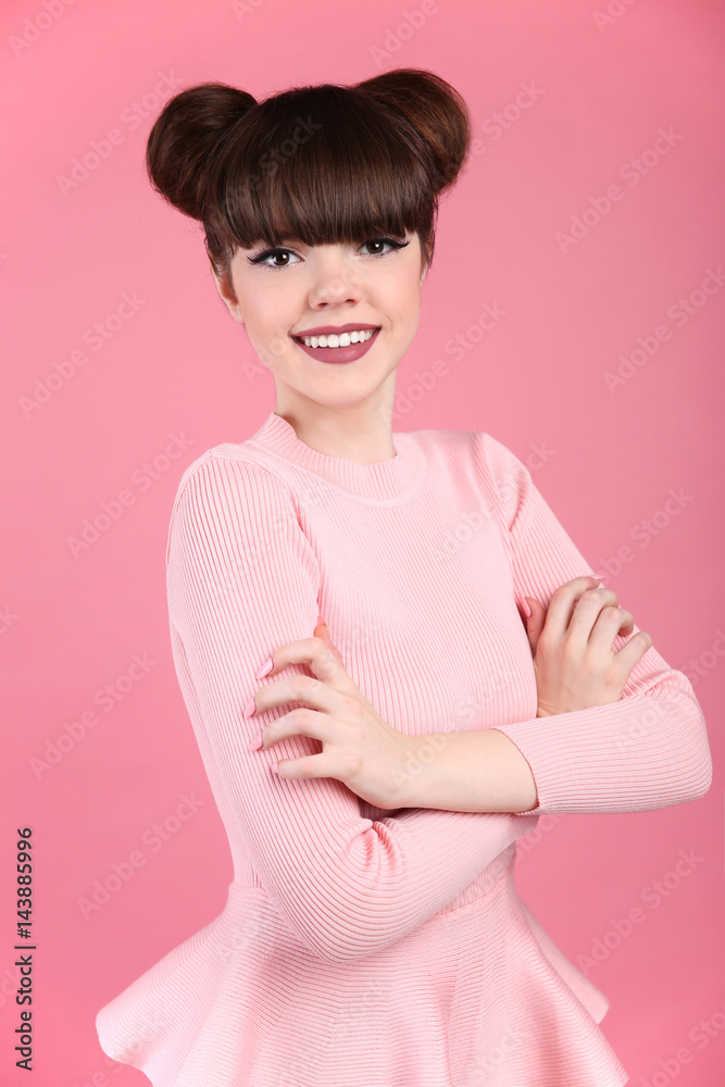 Teen beauty. Hairstyle. Fashion teenage girl model. Happy smiling Brunette with matte lips and funny hair style posing over studio pink background. Teen beauty. Hairstyle. Fashion teenage girl model. Happy smiling Brunette with matte lips and funny hair style posing over studio pink background.