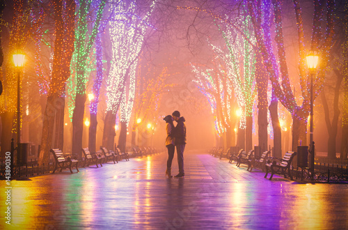 photo of cute couple kissing on the wondeful night park background