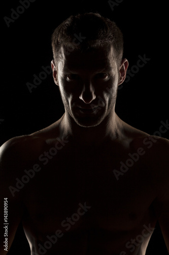 silhouette of handsome young man posing on a dark background