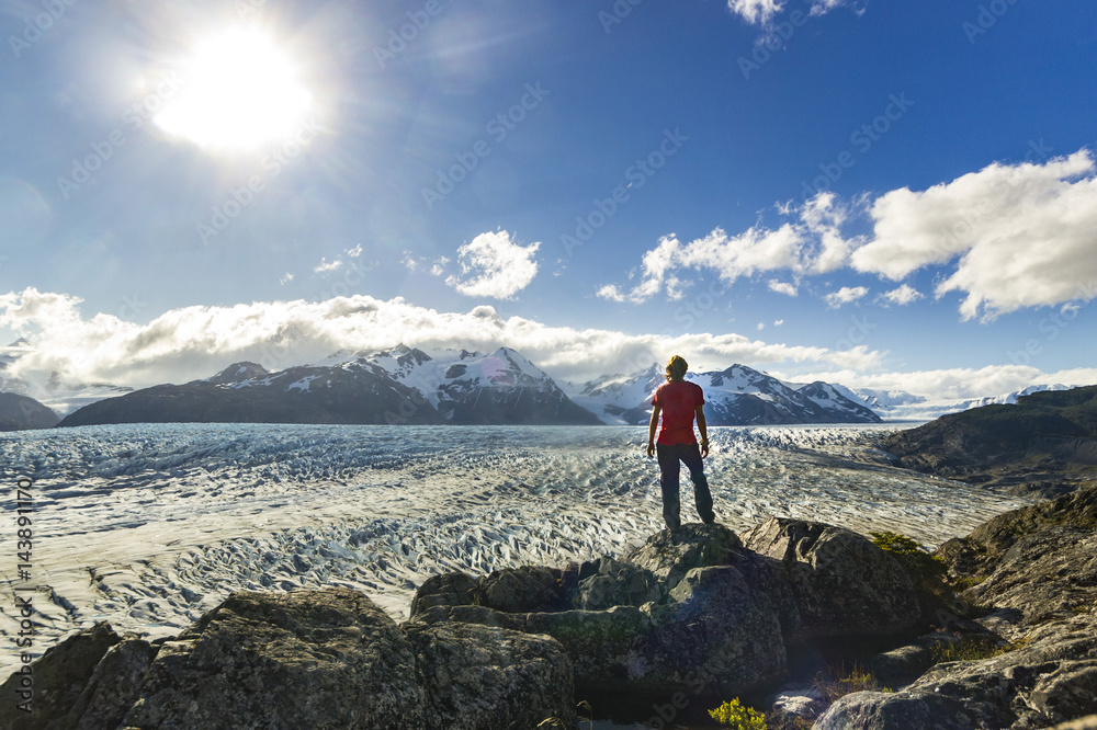 man standing on the stone above Grey glacier in patagonia at sunset