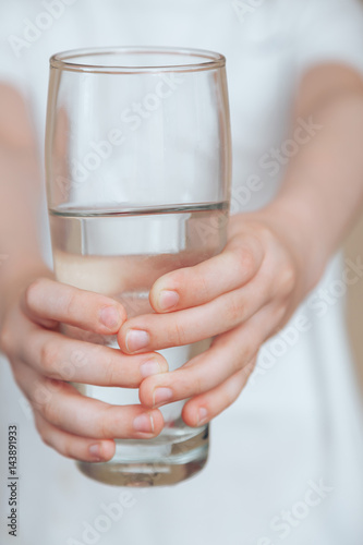 .In the hands of a child a glass of clean water