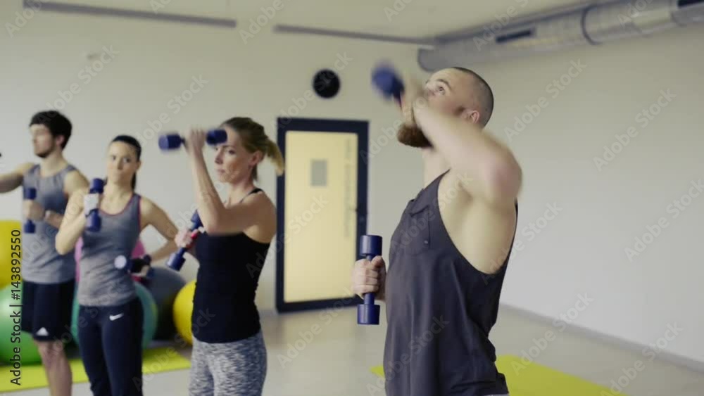 Young people in crossfit gym working their arm Young people in crossfit gym working their arm