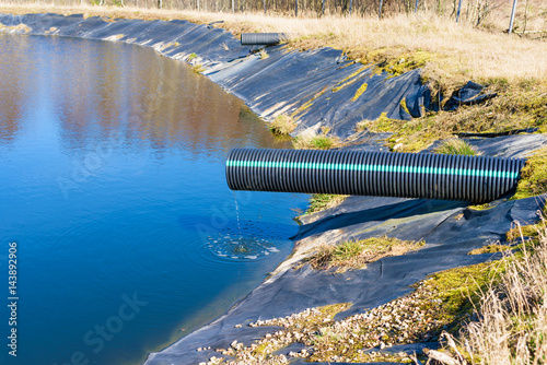 Landfill leachate pouring into pond from a black and blue pipe. Location Ronneby, Sweden. photo