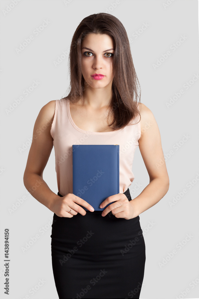 Young beautiful business woman holds a book