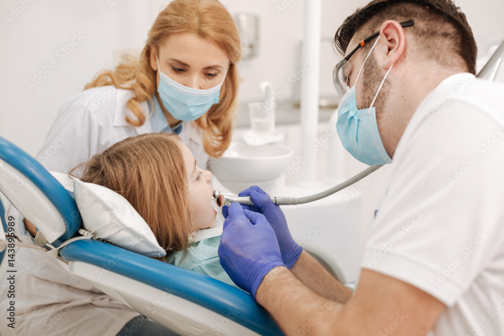 Trained team of dentists conducting work together Trained team of dentists conducting work together