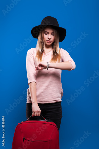 Beautiful young girl on a blue background going travel