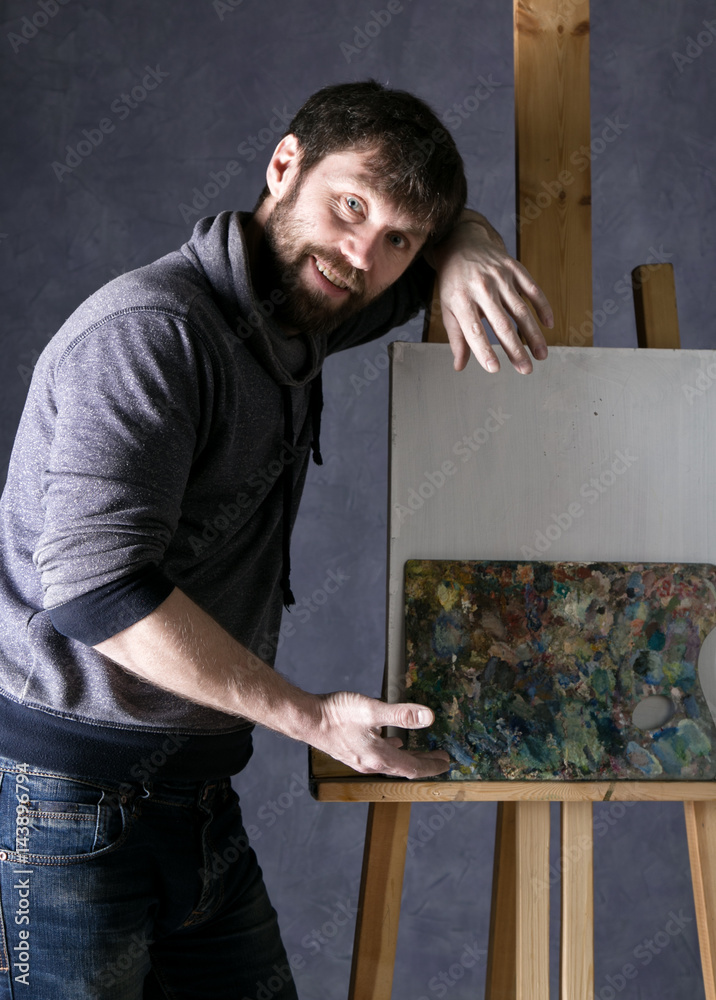 paint artist posing next to a canvas and contemplating, depicts a reverie