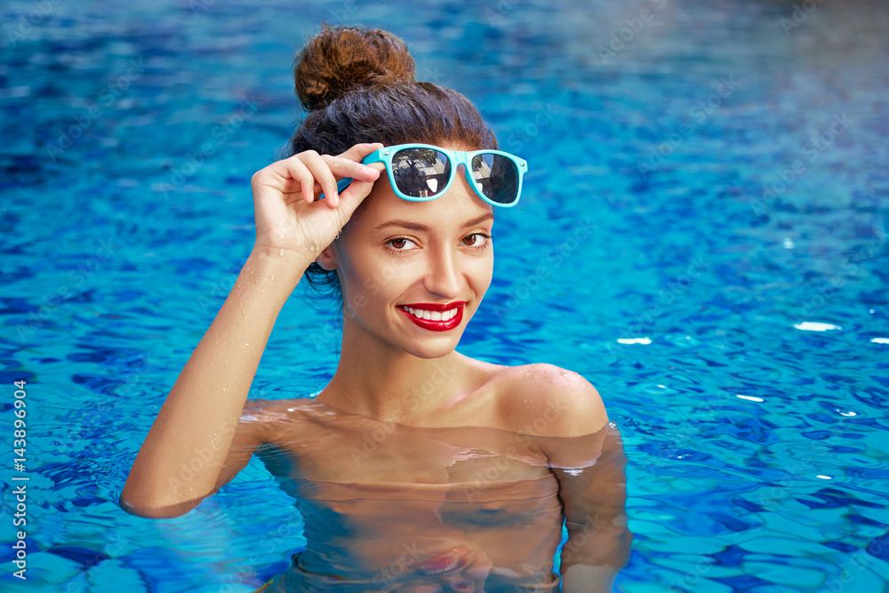 Relaxation and leisure. Beautiful young woman enjoying suntan in resort swimming pool.