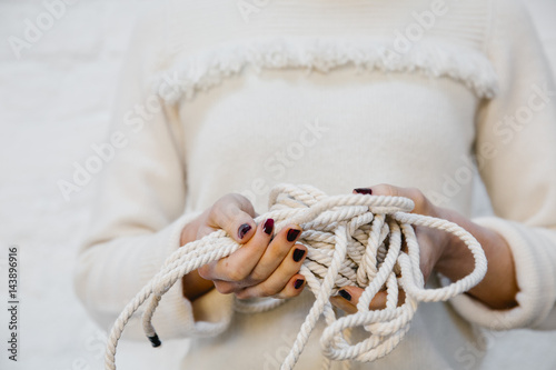 Hands holding white yarns