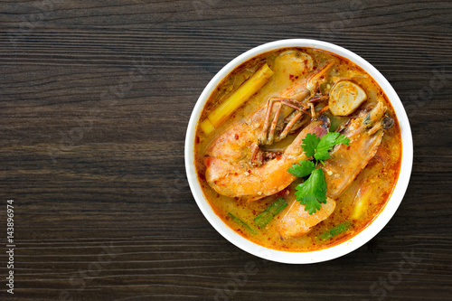 Tom yum kung in white bowl on wooden table, Still life image and Select focus, space for text