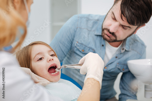 Precise caring dentist drawing childs baby tooth