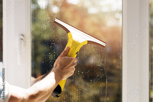 hand cleaning window with vacuum cleaner