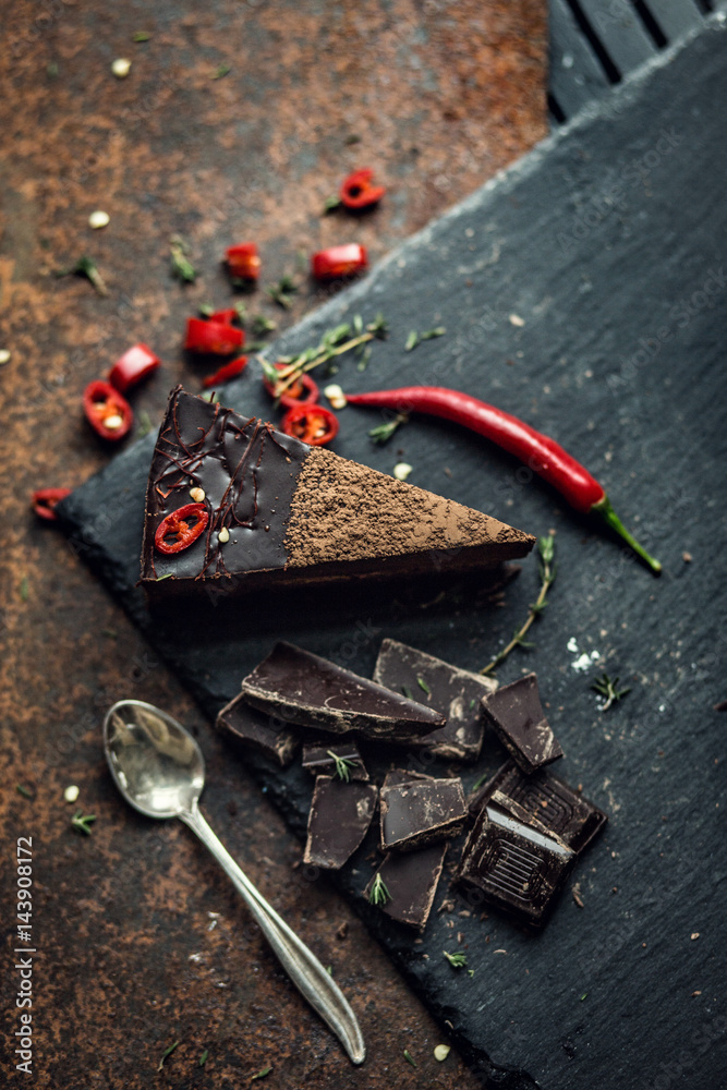 Piece of dark chocolate cake with red hot pepper. The restaurant or cafe atmosphere. Retro. Vintage Piece of dark chocolate cake with red hot pepper. The restaurant or cafe atmosphere. Retro. Vintage