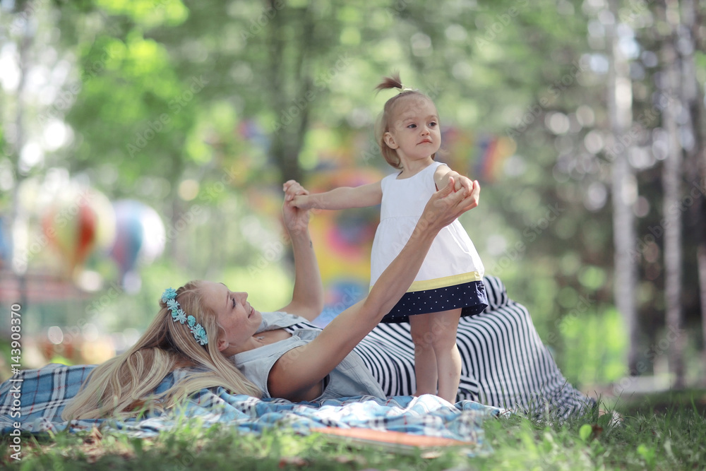 Mom and daughter having fun and playing in the summer park Mom and daughter having fun and playing in the summer park
