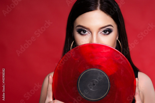 Sexy brunette woman posing in black on red background. S