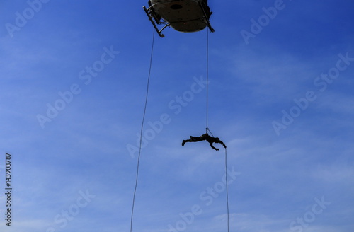 silhouette Soldier Jump rope from helicopter in blue sky