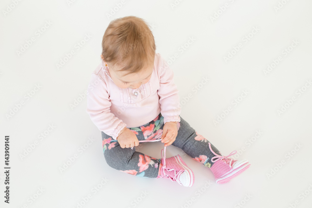Cute little baby girl sitting on floor isolated Cute little baby girl sitting on floor isolated