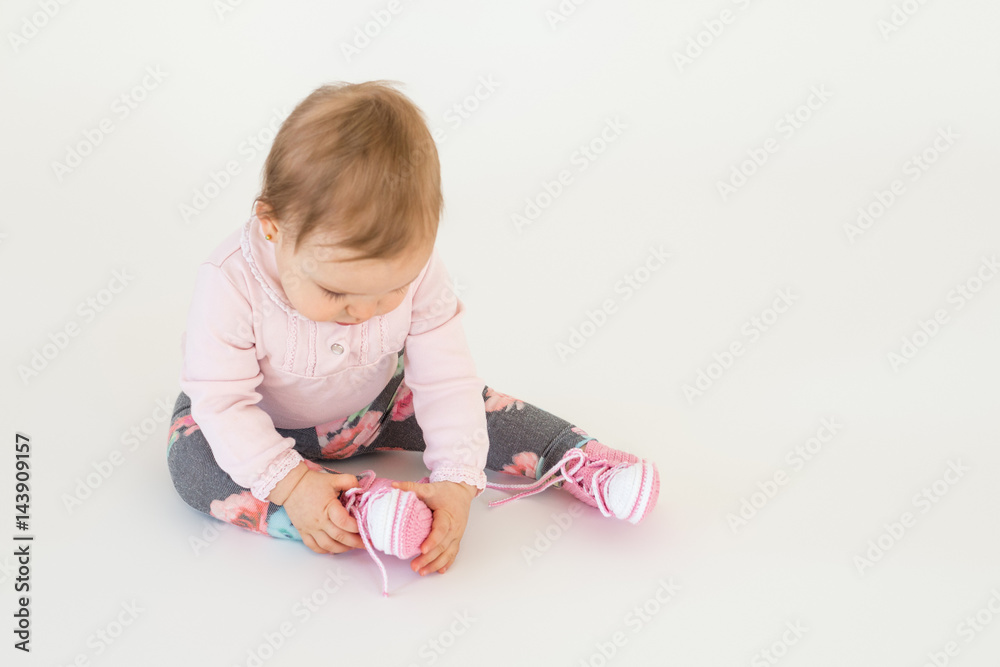 Cute little baby girl sitting on floor isolated Cute little baby girl sitting on floor isolated