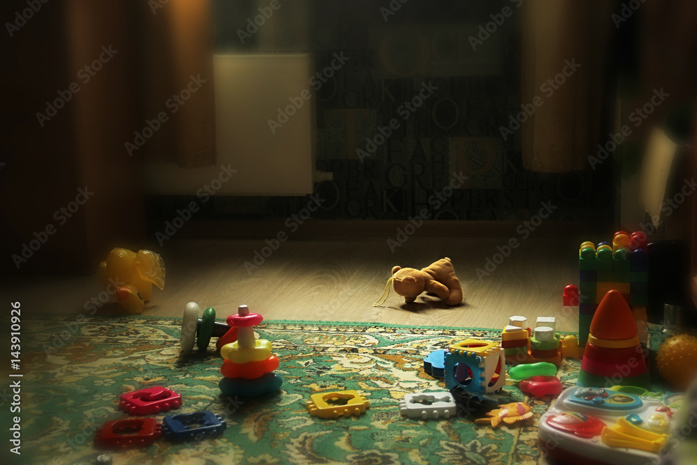 teddy bear lying on the floor. discarded Abandoned bear cub. Scattered toys