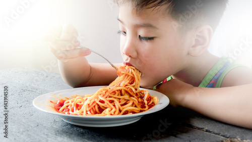 Asian boy eating spaghetti