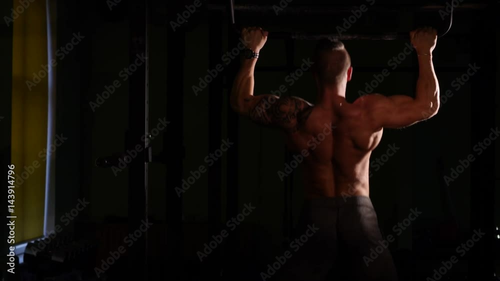 Young bodybuilder training in a gym. Doing pullups. 60 to 24fps 4K Young bodybuilder training in a gym. Doing pullups. 60 to 24fps 4K