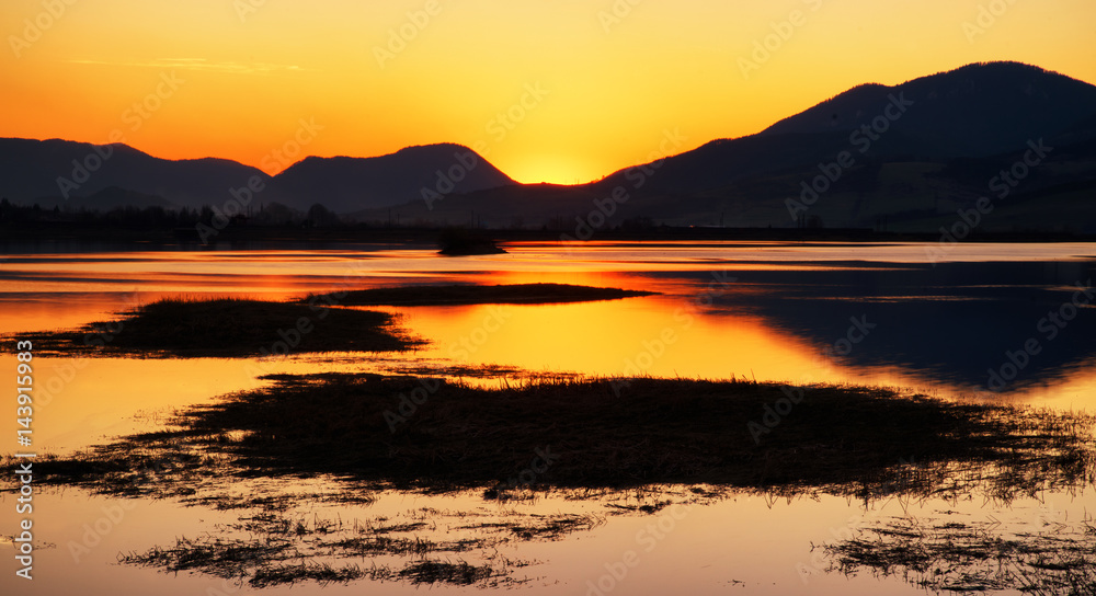 Colorful sunset over lake and mountains