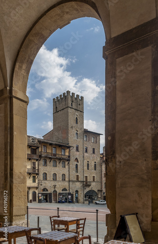 Beautiful vertical view of Piazza Grande and Torre Lappoli tower, Arezzo, Tuscany, Italy, framed by an arch of Vasari's Palazzo delle Logge