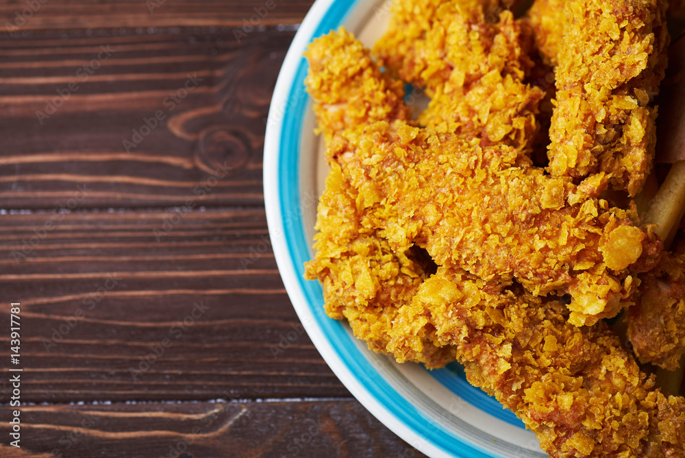 Crispy fried chicken breast on an old rustic wooden background, Close up. With a lot of copy space. Crispy fried chicken breast on an old rustic wooden background, Close up. With a lot of copy space.