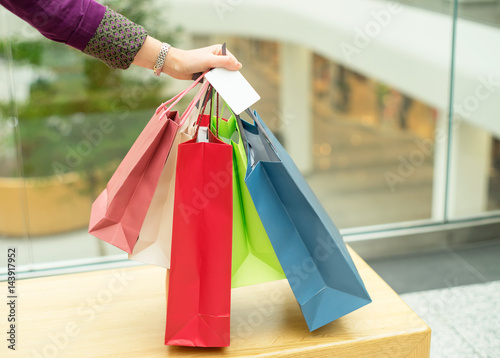 Crop hand holding shopping bags and plastic card